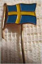 Nål brosch med Svenska flaggan enligt bilderna.